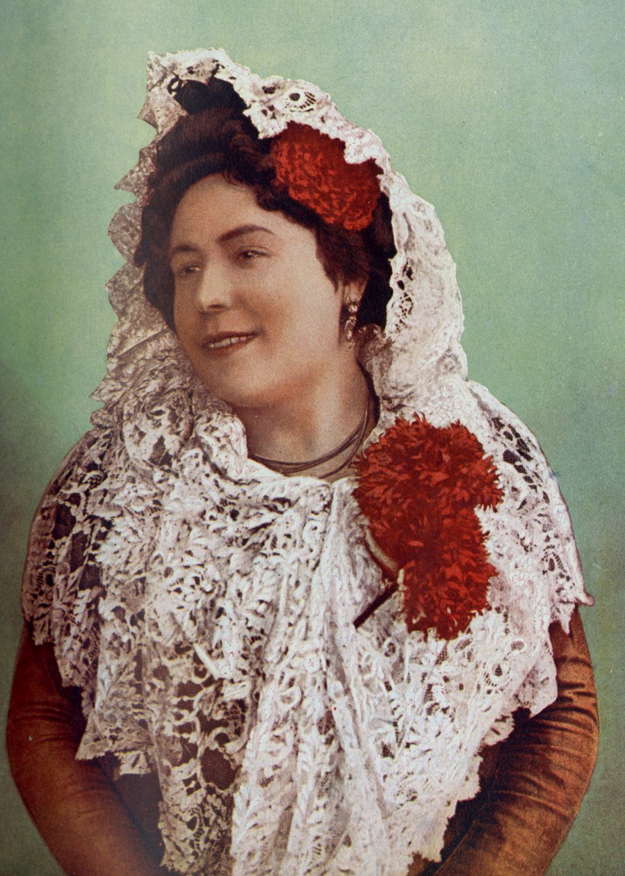 Spagna. Fiori scarlatti e mantiglia di pizzo bianco drappeggiata su capelli e spalle mostrano la bellezza meridionale dell