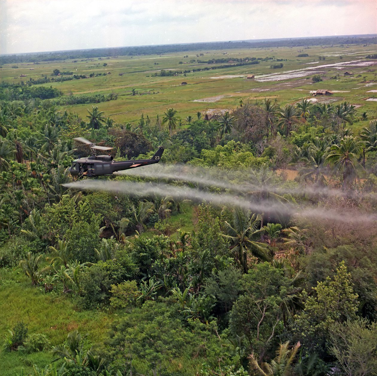 Un elicottero UH-1D della 336a Compagnia di Aviazione spruzza un agente defoliante su una fitta area di giungla nel Delta del Mekong, 26 luglio 1969 da American Photographer