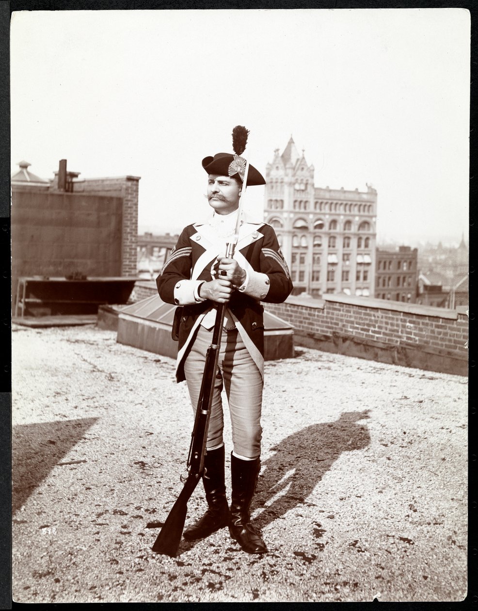 Un uomo su un tetto vestito in uniforme militare tradizionale, con un fucile, 1895 da Byron Company