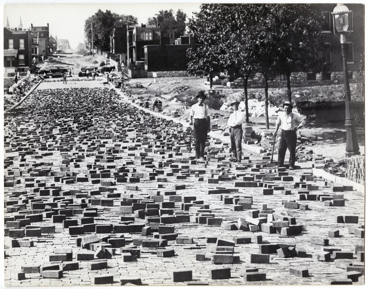 Tre uomini che lavorano per pavimentare una strada con mattoni, Compton vicino a Meramec da Charles Clement Holt