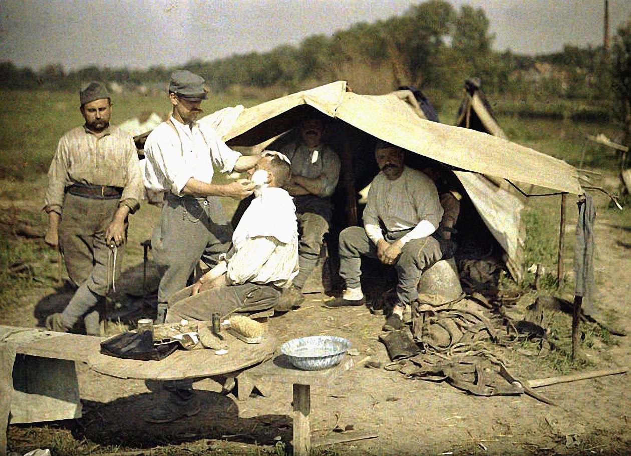 Soldato rasato da un barbiere in un accampamento militare francese, Soissons, Aisne, Francia, 1917 da Fernand Cuville