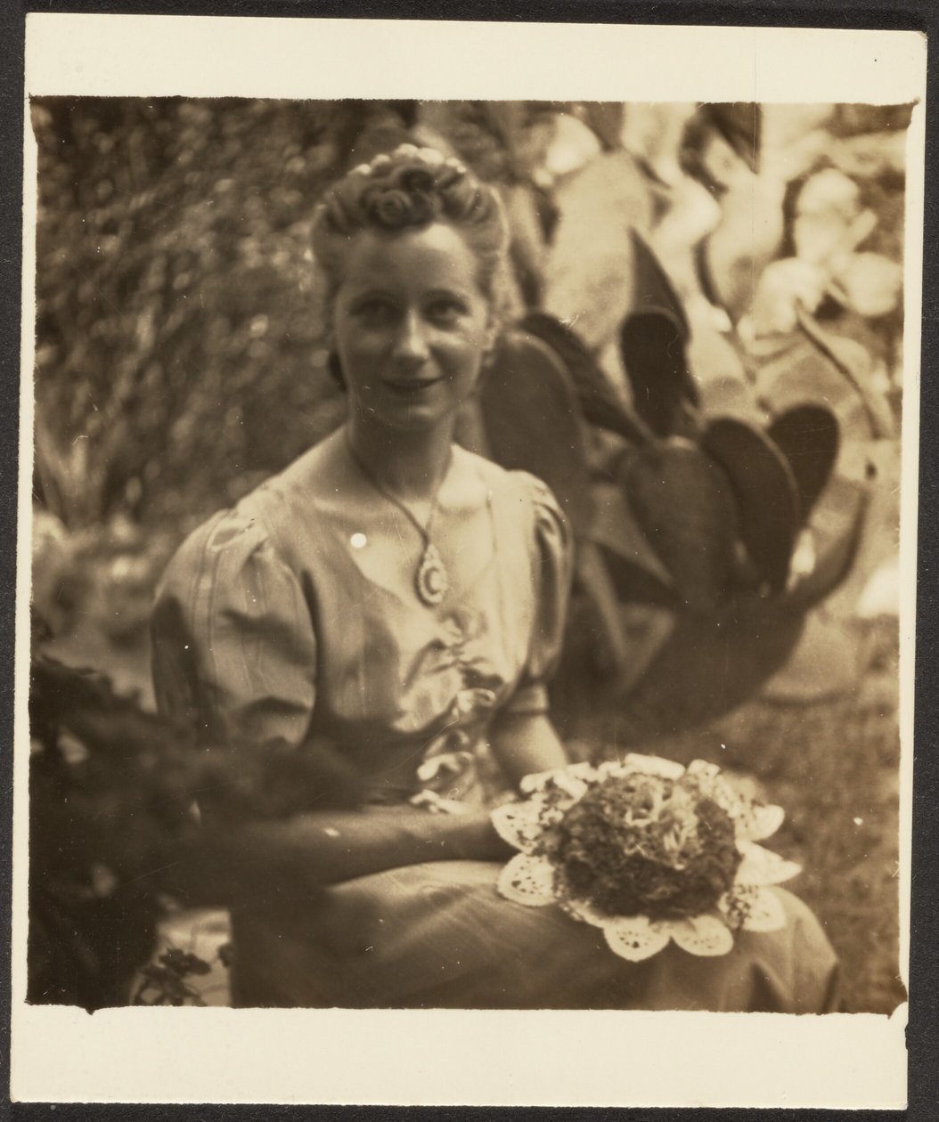[Donna con mazzo di fiori seduta davanti a un cactus] da Louis Fleckenstein
