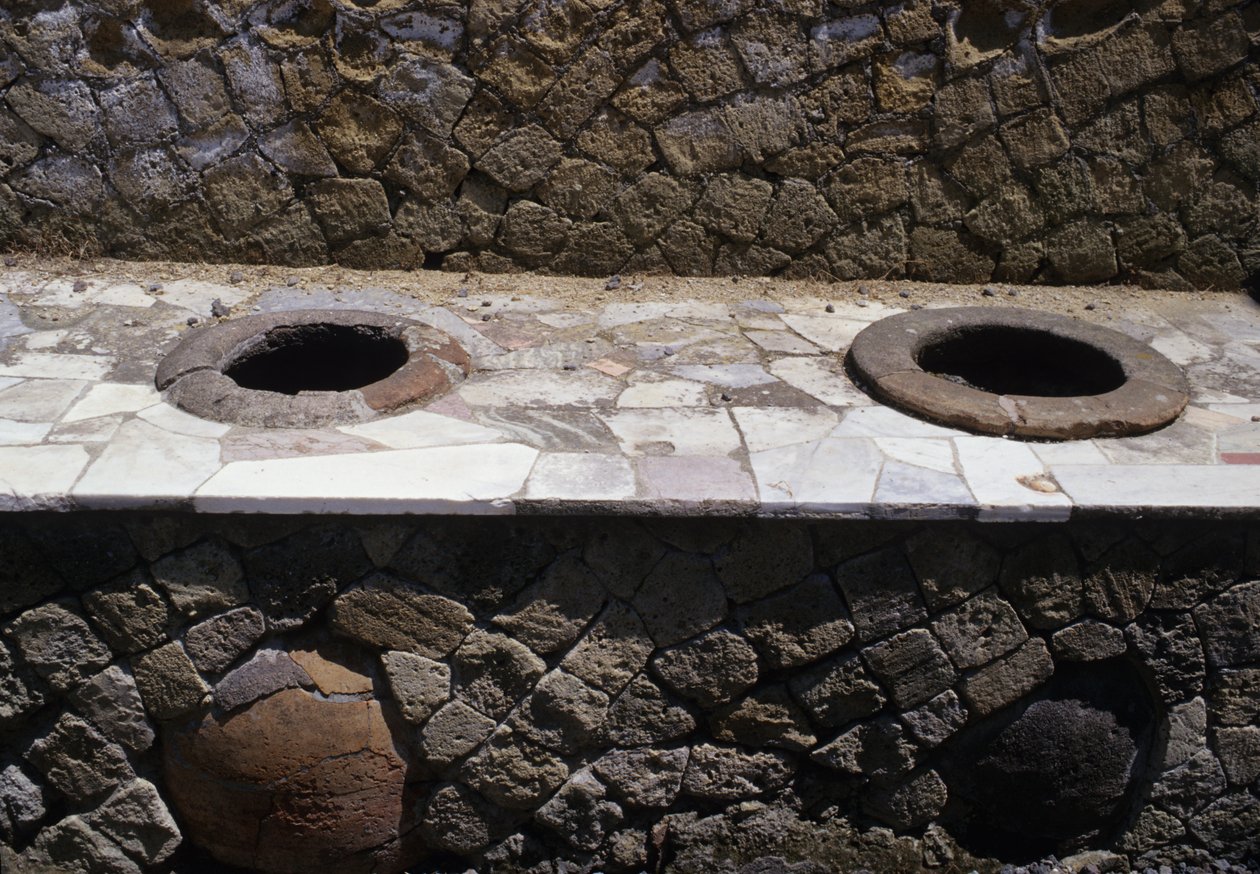 Resti restaurati di un thermopolium (snack bar) con ciotole incassate nel bancone da Roman