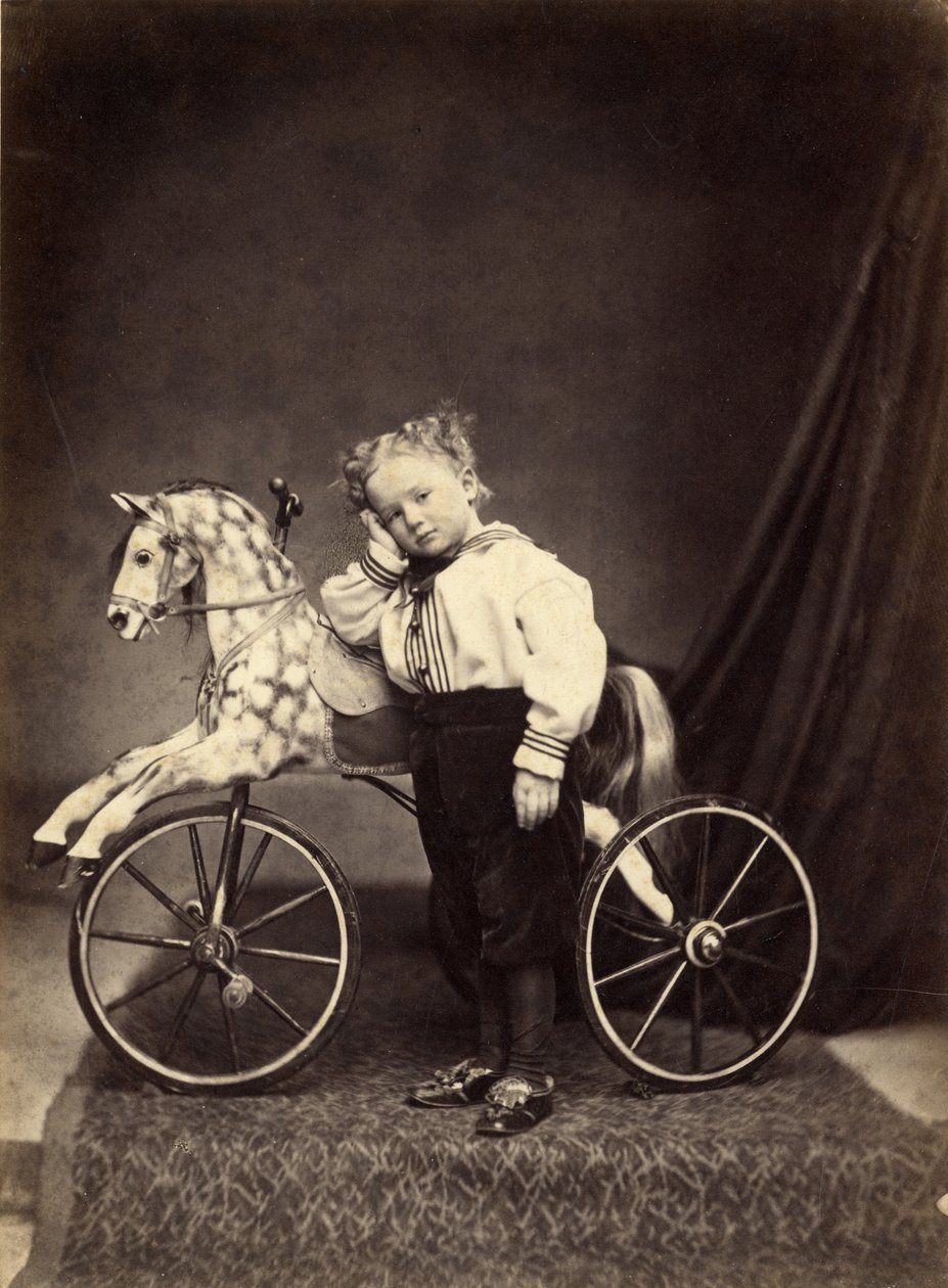 Ragazzo giovane accanto al suo cavallo montato come un triciclo, 1860s da T. Seed