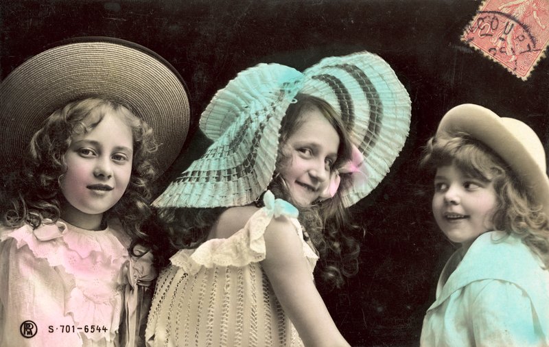 Tre giovani ragazze con cappelli, sorridenti da French Photographer